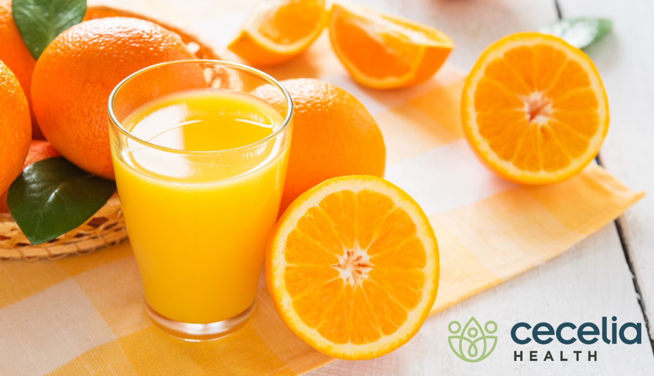 oranges laid on a table next to a glass of orange juice