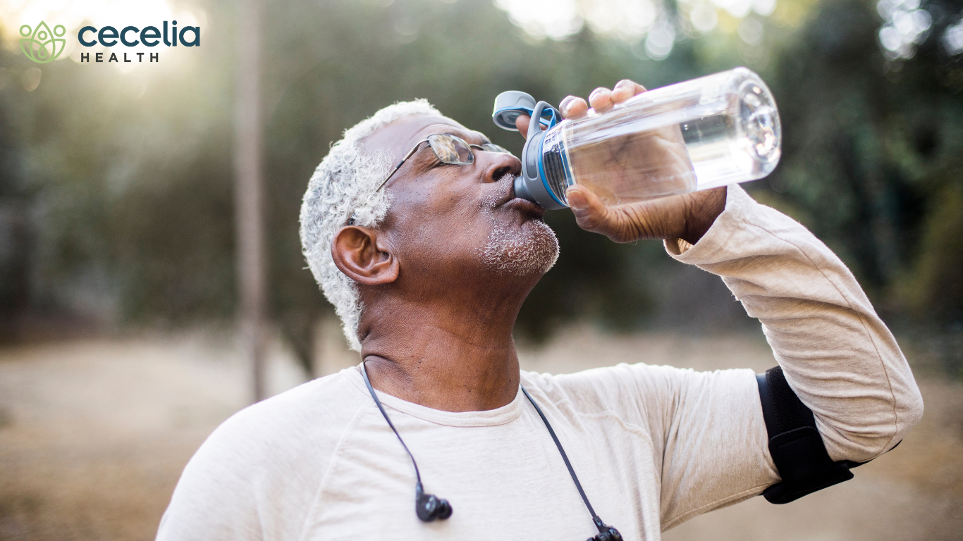 older man drinking water outside