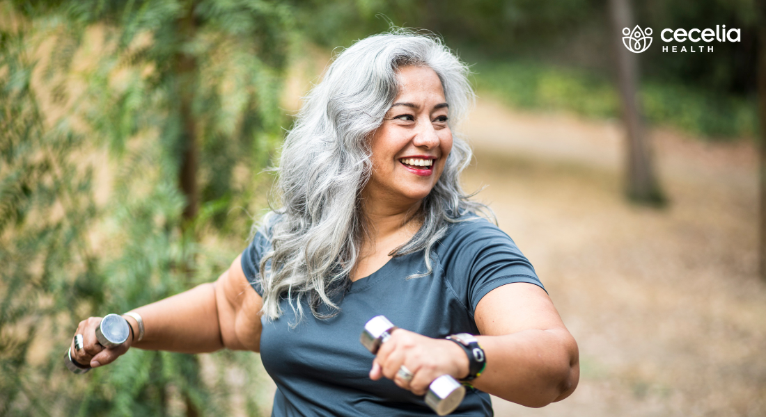 woman outdoors lifting small hand weights