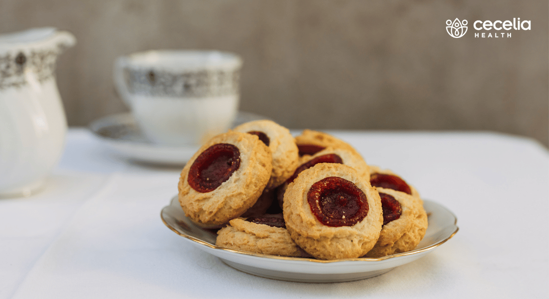 plate of jam thumbprint cookies and glass of milk