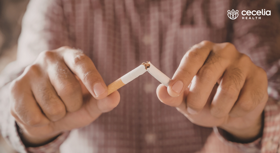 man breaking cigarette in half