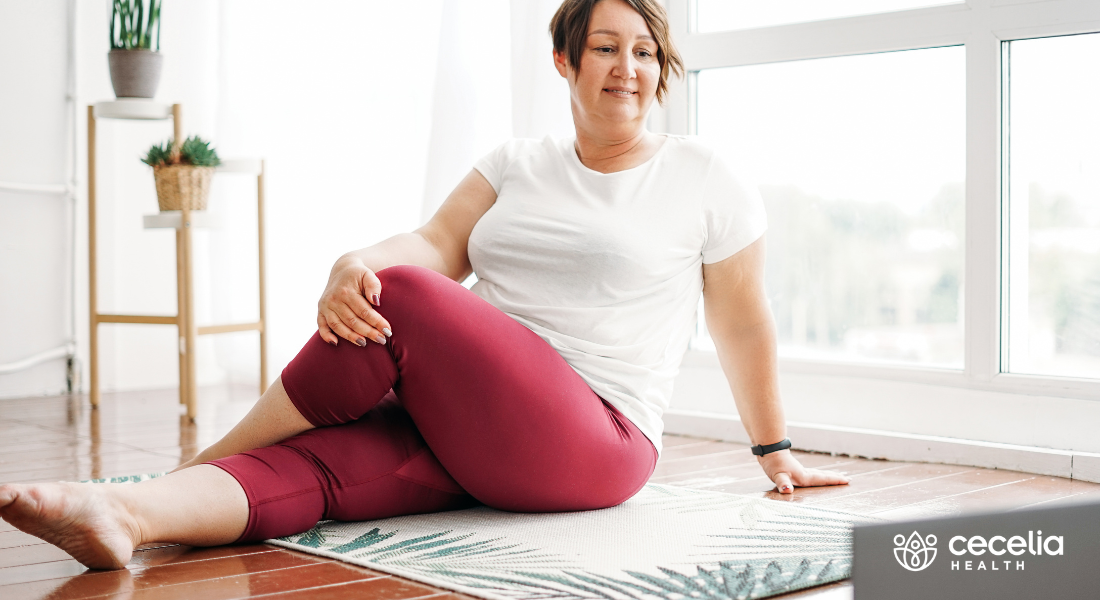 woman doing yoga indoors watching laptop