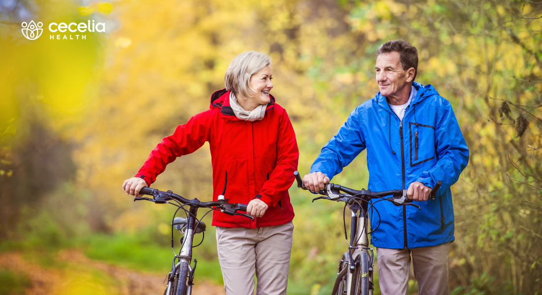 older adults walking next to their bikes in the fall